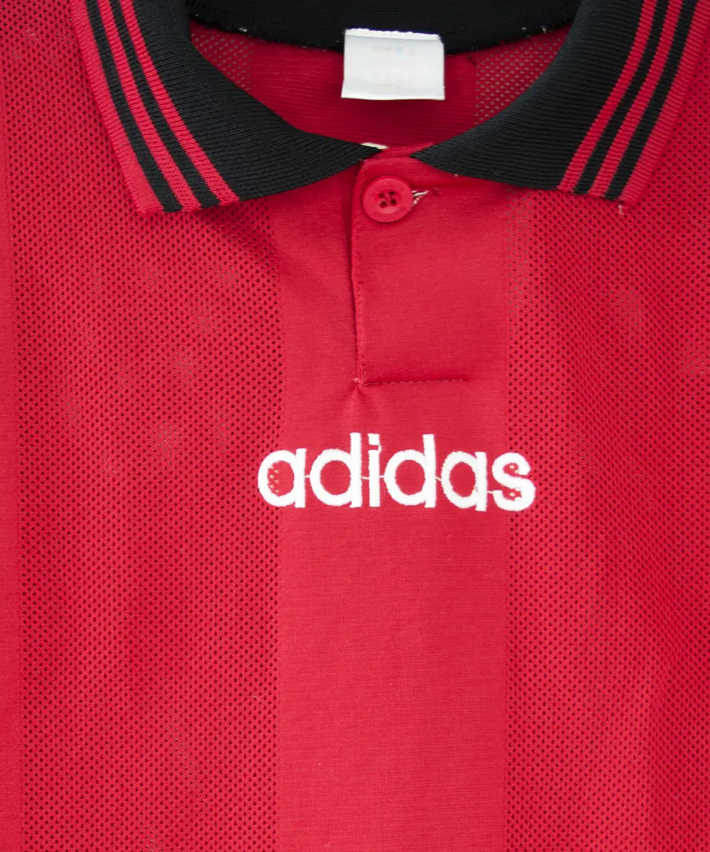 Maillot domicile rouge et noir de l'EA Guingamp de la saison 1996/1997. On peut retrouver le sponsor fromage rippoz et l'équipementier adidas
