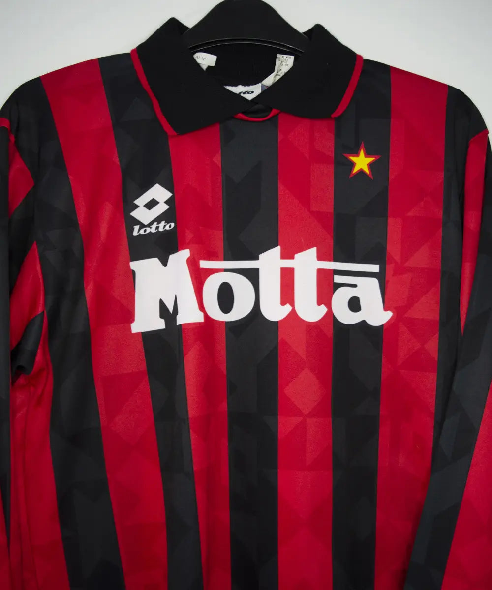 Maillot vintage domicile rouge et noir de l'AC Milan de la saison 1993-1994. On peut retrouver l'équipementier lotto et le sponsor motta