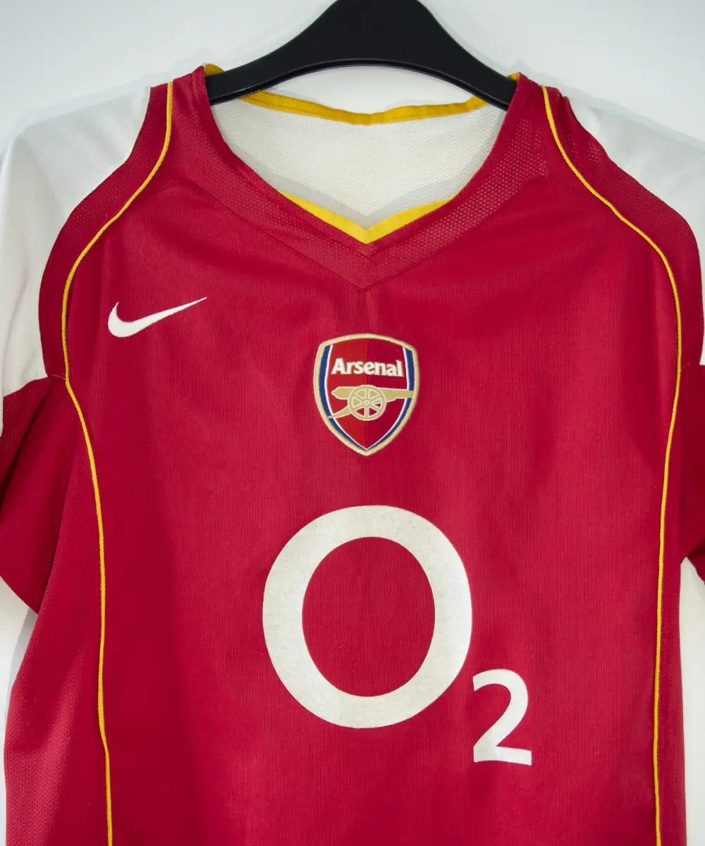 Maillot vintage domicile rouge et blanc d'arsenal de la saison 2004-2005. On peut retrouver le sponsor O2 et l'équipementier nike.