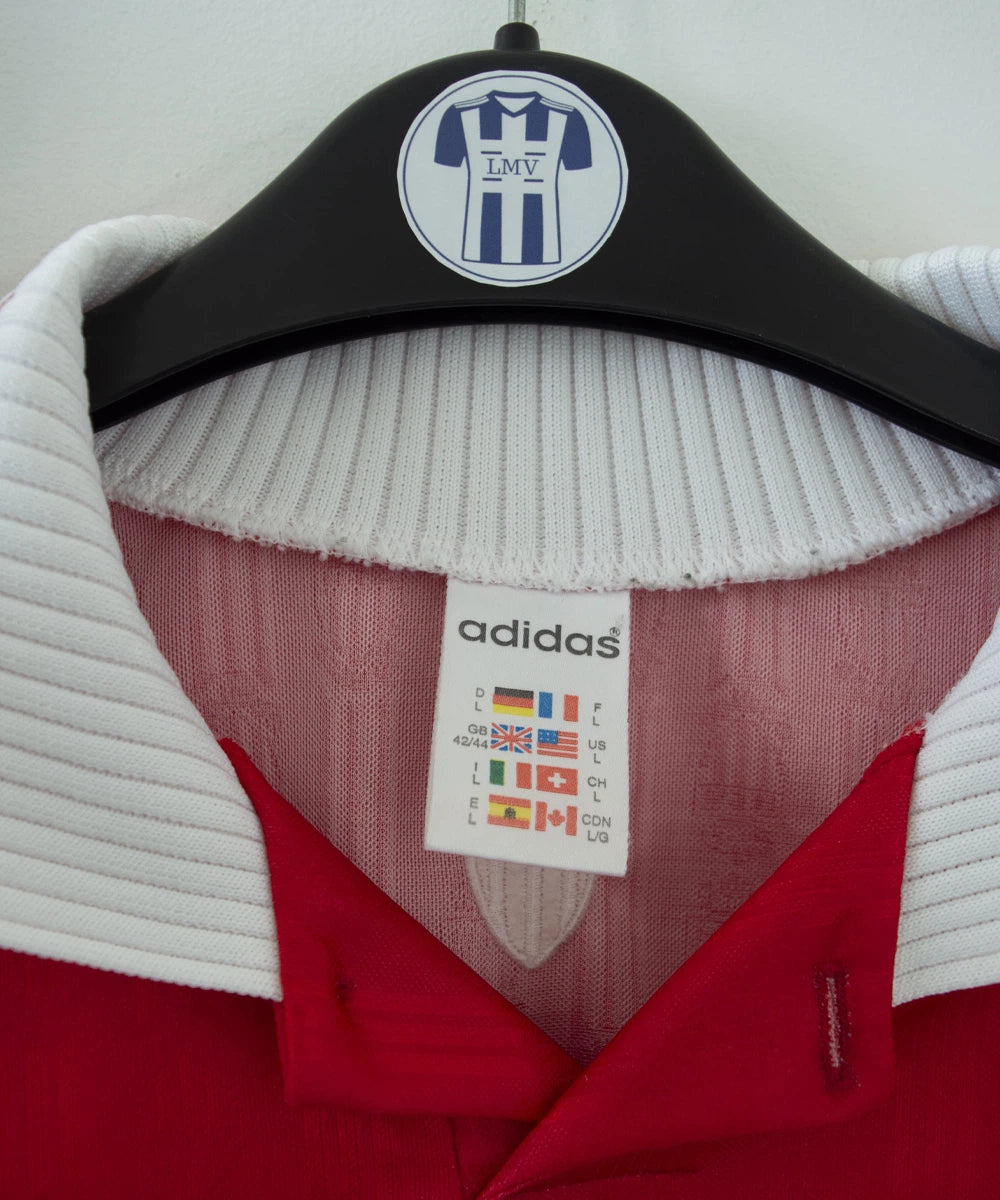Maillot de foot vintage domicile rouge et blanc de l'AS Monaco de la saison 1996/1998. On peut retrouver l'équipementier adidas et le sponsor Eurest. Il s'agit d'un maillot authentique