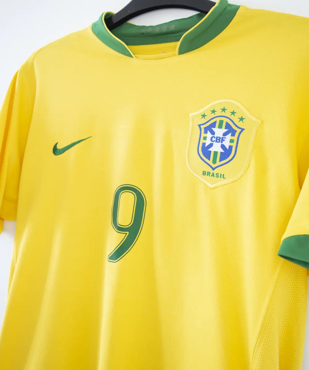 Maillot brésil jaune et vert porté lors de la coupe du monde 2006. On peut retrouver l'équipementier nike. Le maillot est floqué du numéro 9 Ronaldo. Sur cette photo on peut voir le devant du maillot de côté
