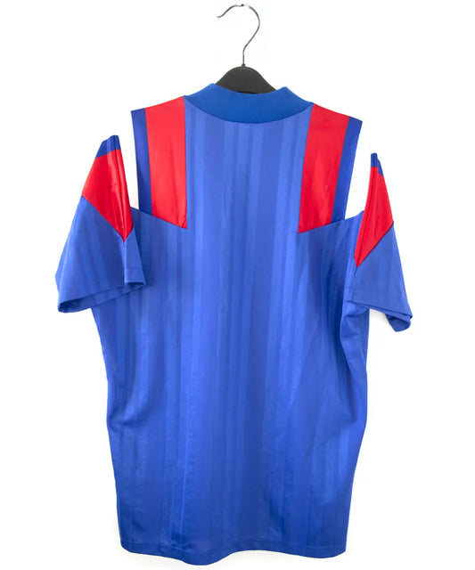 Maillot domicile de l'équipe de france 1992 de couleur bleu blanc et rouge. On peut retrouver l'équipementier adidas