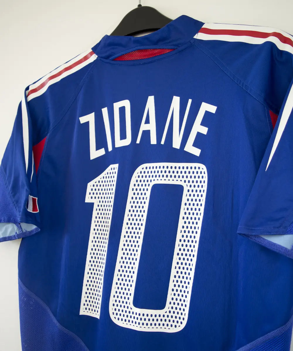 Maillot domicile de l'équipe de france 2004 2006 de couleur bleu blanc et rouge. On peut retrouver l'équipementier adidas. Le maillot est floqué du numéro 10 Zidane