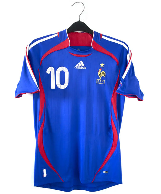 Maillot domicile vintage bleu de l'équipe de france 2006. On peut retrouver l'équipementier adidas. Le maillot est floqué du numéro 10 Zinedine Zidane
