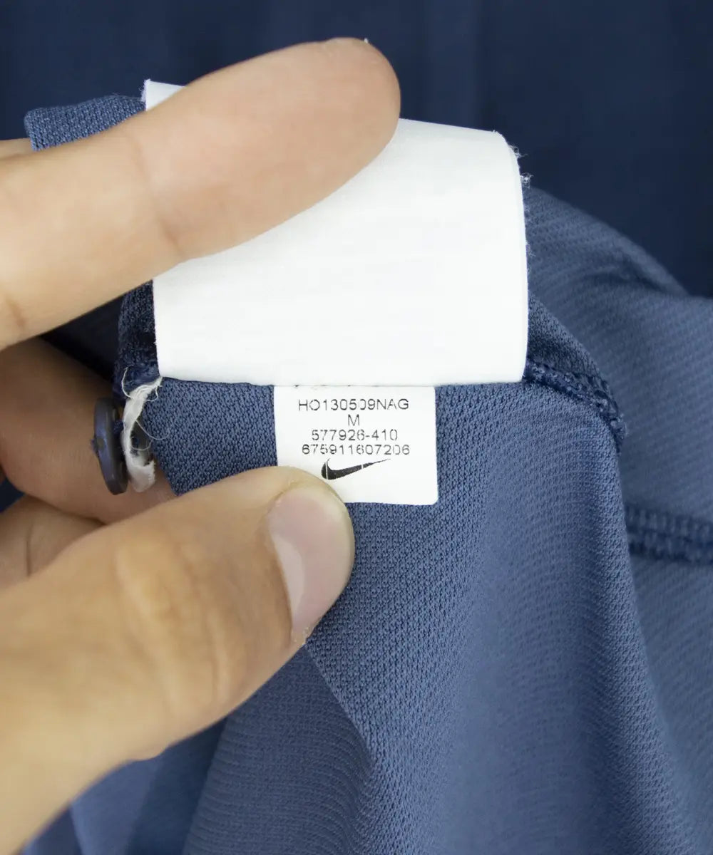 Maillot domicile équipe de france édité lors de la coupe du monde 2014. Le maillot est de couleur bleu et blanc. On peut retrouver l'équipementier nike. Le maillot est floqué du numéro 4 Varane. Sur cette photo on peut voir l'étiquette du maillot comportant les numéros 577926-410