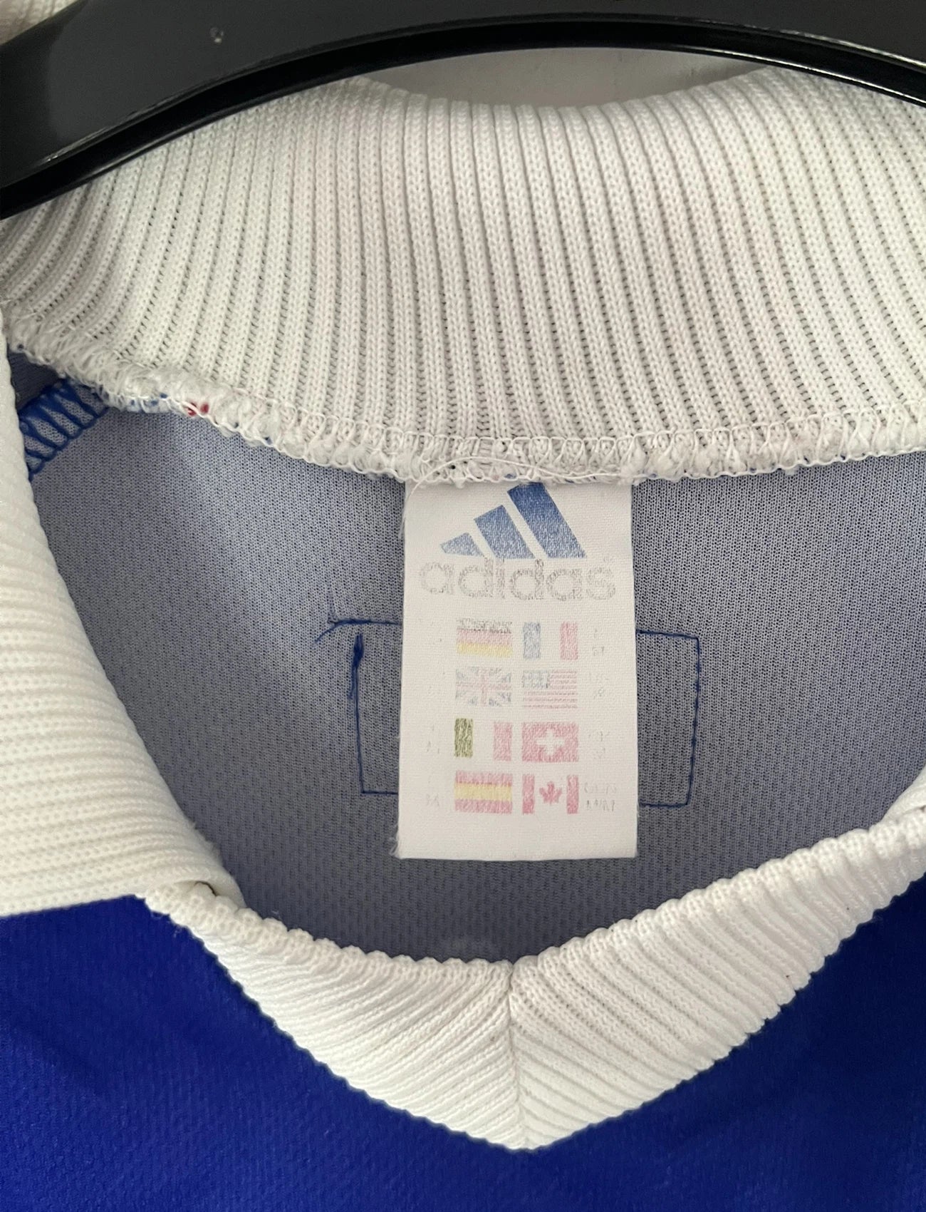 Maillot de foot vintage bleu, blanc et rouge de l'équipe de france 1998. On peut retrouver l'équipementier adidas. Il s'agit d'un maillot authentique édité avant la finale de la coupe du monde car celui-ci ne possède pas l'étoile. Le maillot est floqué du numéro 10 Zidane
