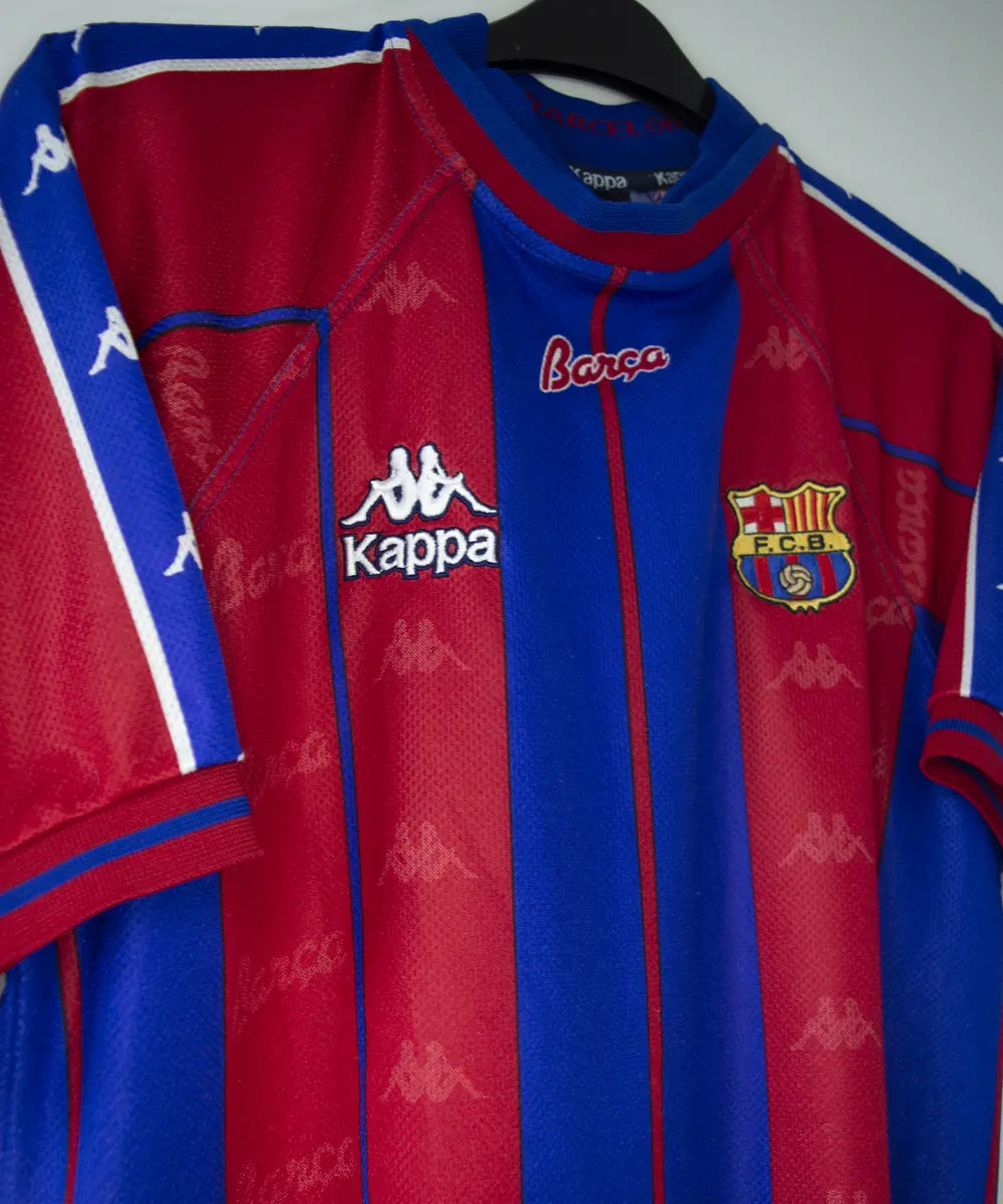 Maillot domicile du fc barcelone de la saison 1997-1998. Le maillot est de couleur rouge et bleu. On peut retrouver l'équipementier kappa