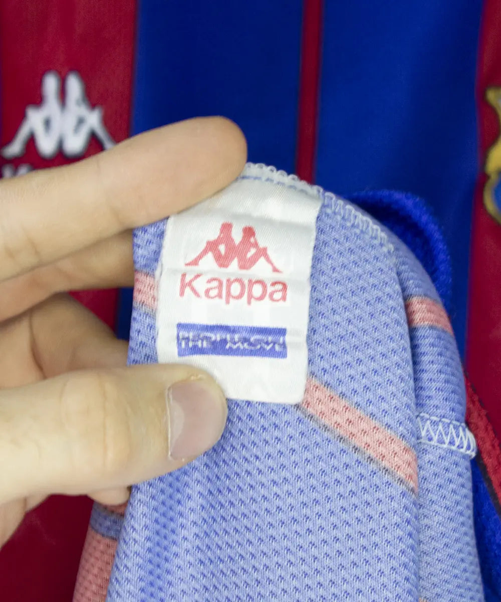 Maillot domicile du fc barcelone de la saison 1997-1998. Le maillot est de couleur rouge et bleu. On peut retrouver l'équipementier kappa