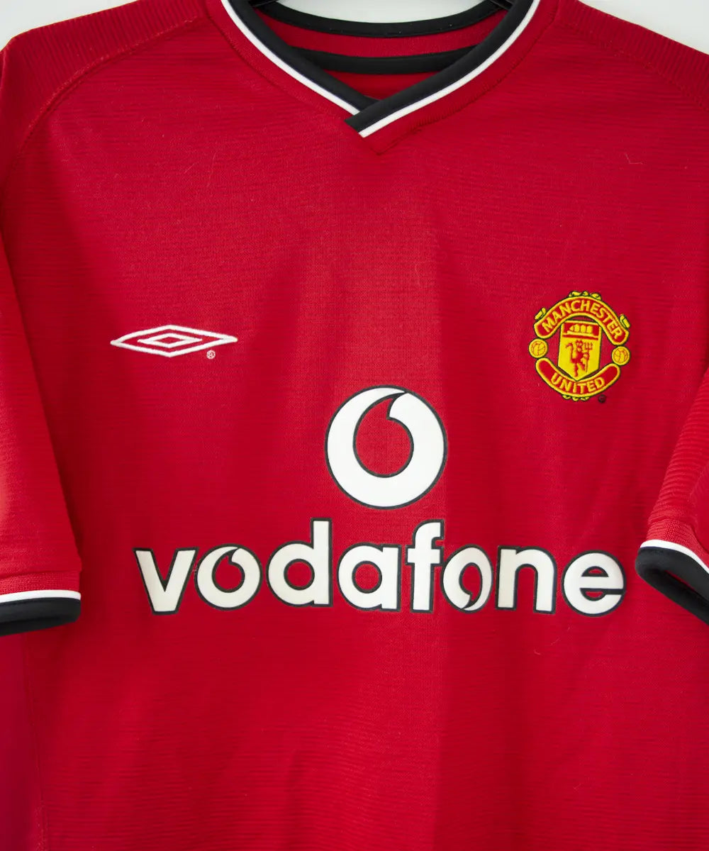 Maillot domicile rouge et noir de manchester united édité lors de la saison 2000-2002. On peut retrouver l'équipementier umbro et le sponsor vodafone