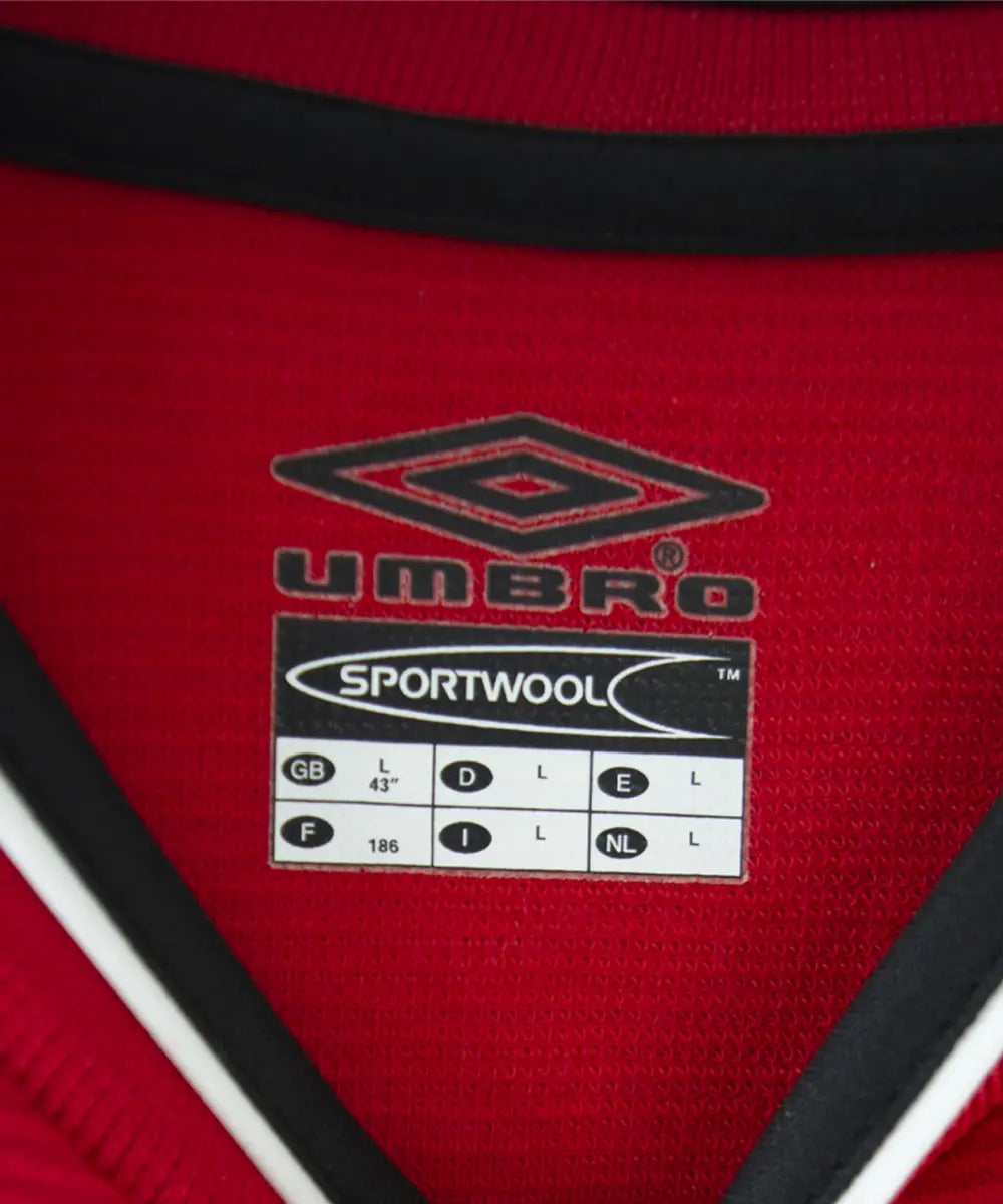 Maillot domicile rouge et noir de manchester united édité lors de la saison 2000-2002. On peut retrouver l'équipementier umbro et le sponsor vodafone