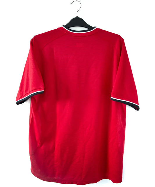 Maillot domicile rouge et noir de manchester united édité lors de la saison 2000-2002. On peut retrouver l'équipementier umbro et le sponsor vodafone