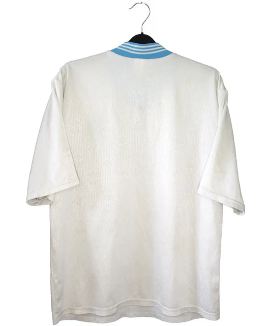 Maillot vintage domicile banc et bleu de l'OM de la saison 1997-1998. On peut retrouver l'équipementier adidas et le sponsor ericsson