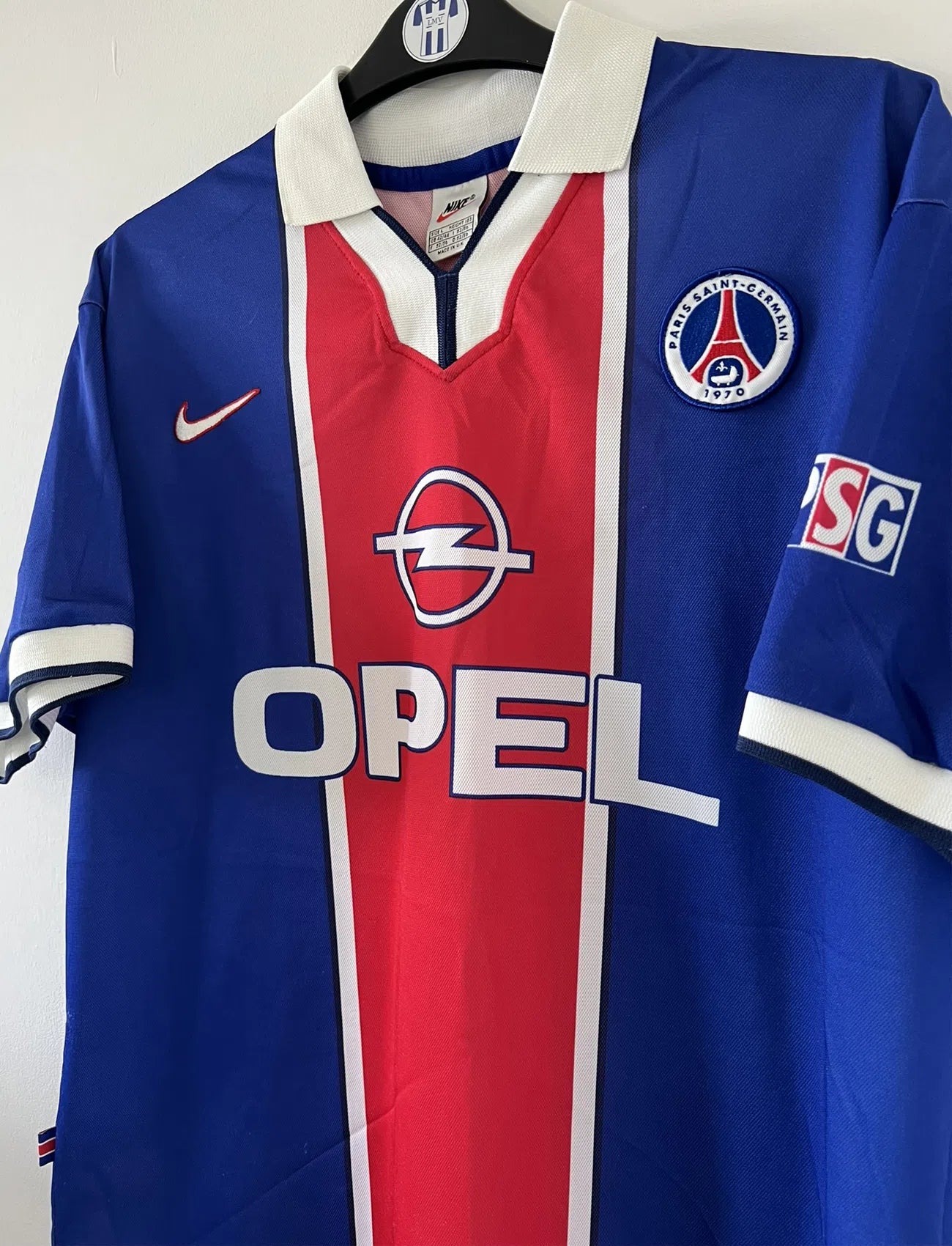 Maillot de foot vintage bleu blanc et rouge du PSG de la saison 1997/1998. On peut retrouver l'équipementier nike et le sponsor Opel. Il s'agit d'un maillot authentique.