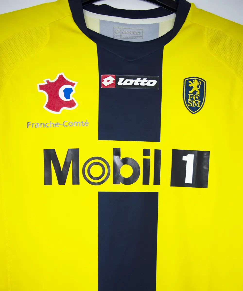 Maillot domicile du Sochaux Montbéliard FC de couleur jaune et bleu de la saison 2008-2009. On peut retrouver l'équipementier Lotto et le sponsor Mobile 1. Le maillot est floqué du numéro 9 Mevlut Erding