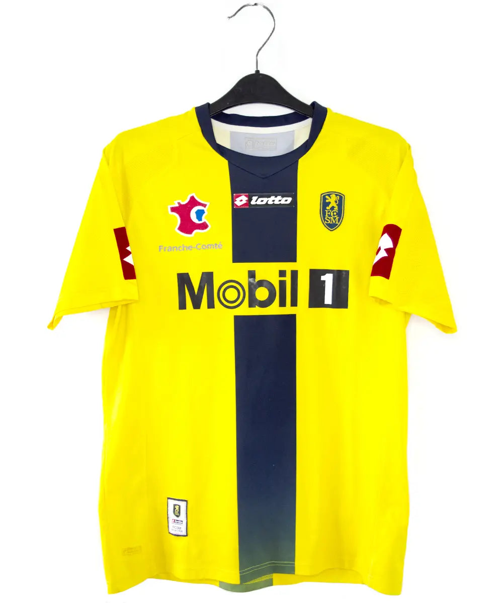 Maillot domicile du Sochaux Montbéliard FC de couleur jaune et bleu de la saison 2008-2009. On peut retrouver l'équipementier Lotto et le sponsor Mobile 1. Le maillot est floqué du numéro 9 Mevlut Erding