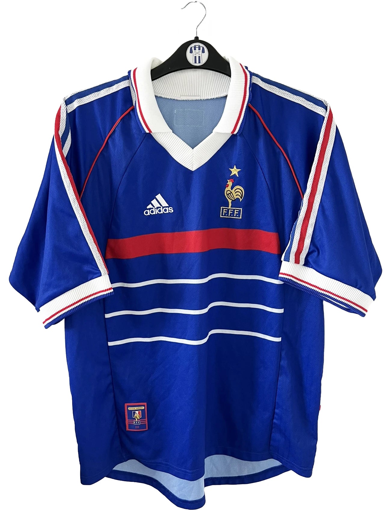 Maillot de foot vintage bleu, blanc et rouge de l'équipe de france 1998. On peut retrouver l'équipementier adidas. Il s'agit d'un maillot authentique d'époque