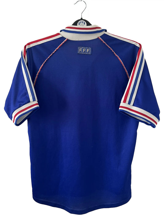 Maillot de foot vintage domicile bleu de l'Equipe de France 1998. On peut retrouver l'équipementier adidas. Il s'agit d'un maillot authentique d'époque.