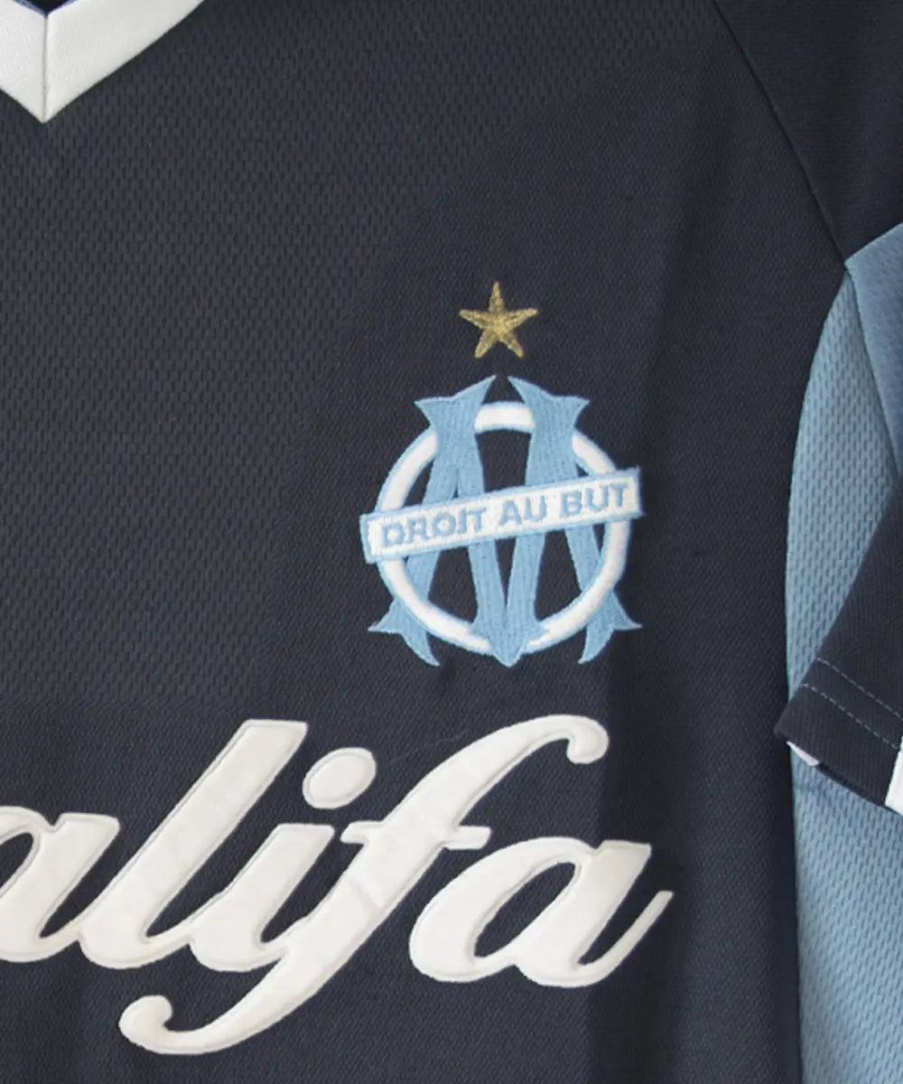 Maillot extérieur de l'OM de couleur bleu, blanc et noir. On peut retrouver l'équipementier adidas et le sponsor khalifa airways