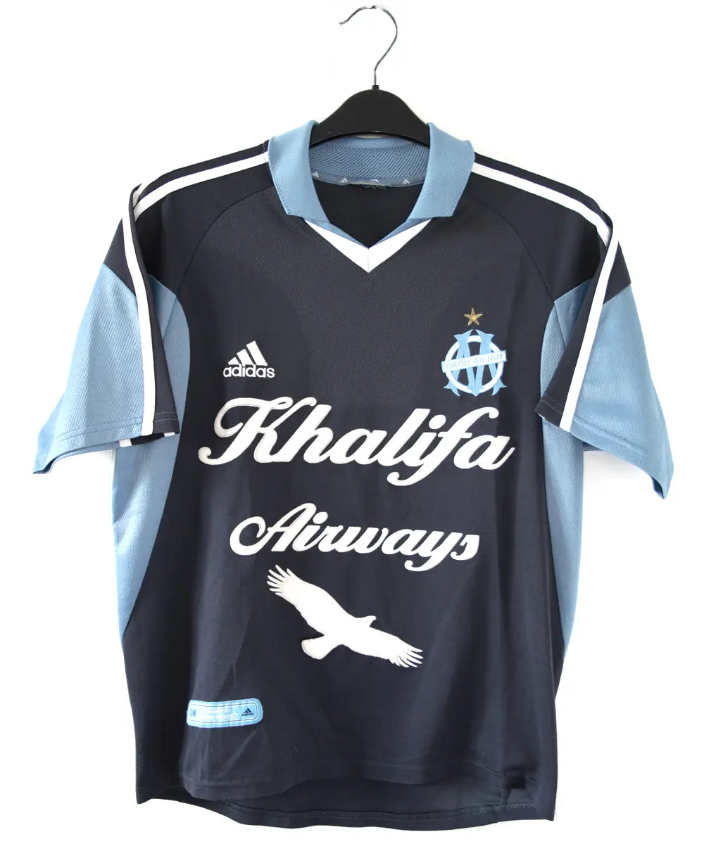 Maillot extérieur de l'OM de couleur bleu, blanc et noir. On peut retrouver l'équipementier adidas et le sponsor khalifa airways