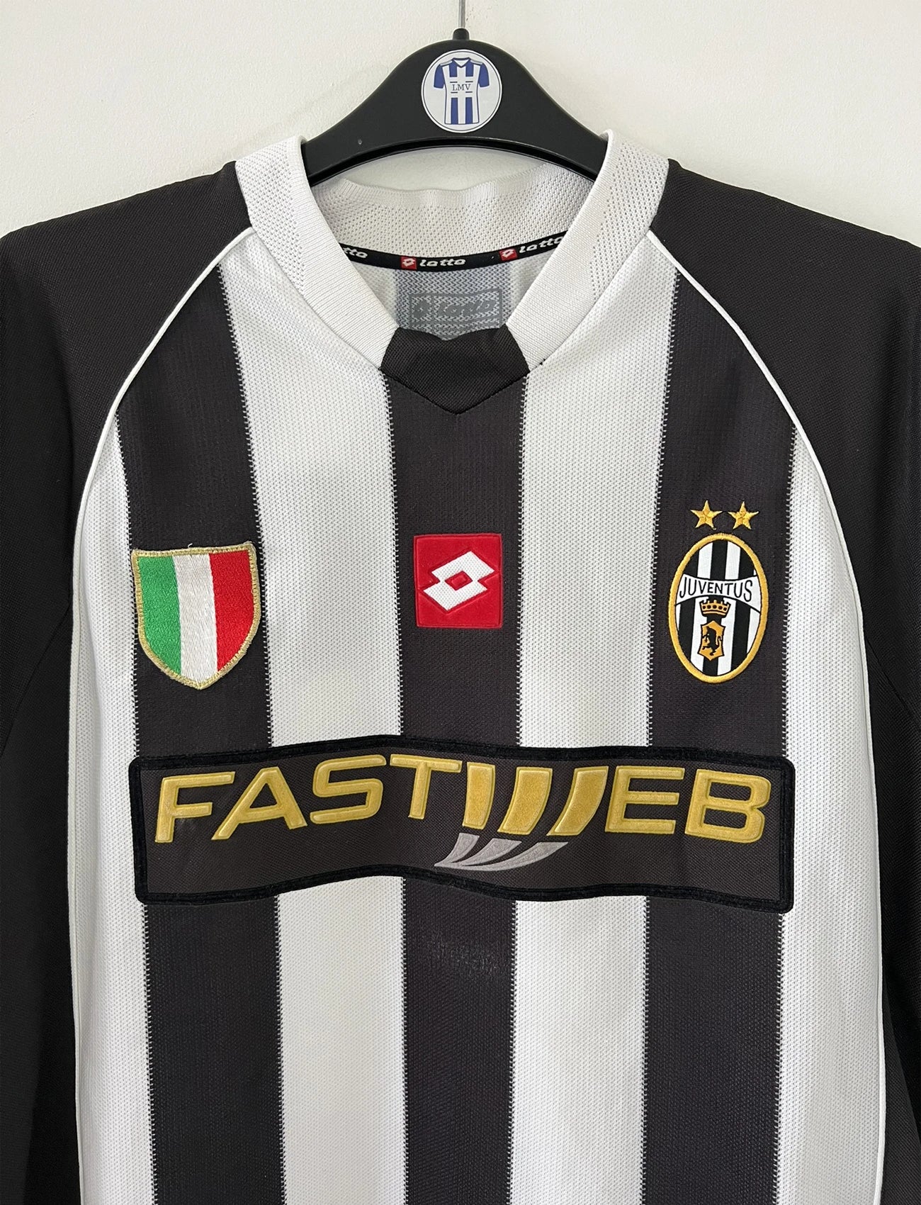 Maillot de foot vintage domicile noir et blanc de la juventus de turin de la saison 2002/2003. On peut retrouver l'équipementier lotto et le sponsor fastweb. Il s'agit d'un maillot authentique d'époque.