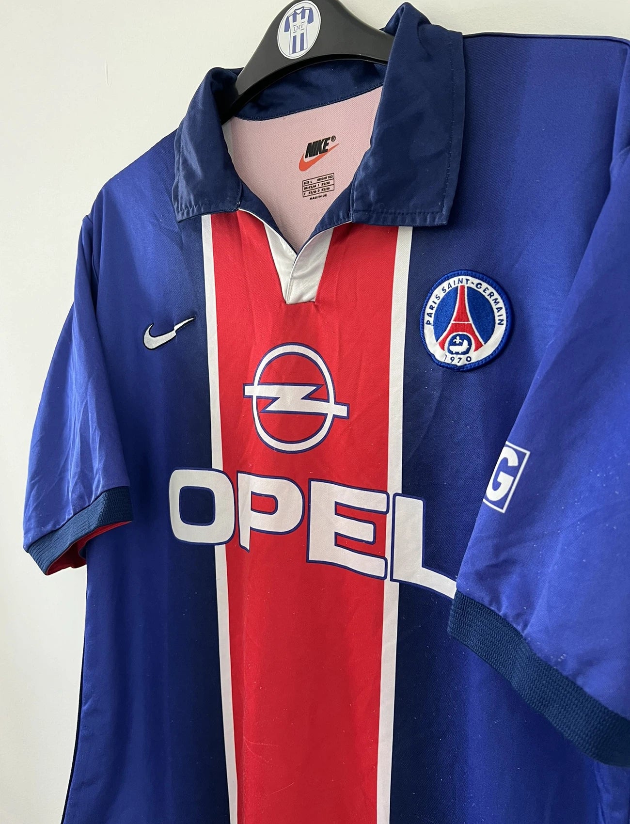 Maillot de foot vintage domicile du PSG de la saison 1998/1999. Le maillot est de couleur bleu blanc et rouge. On peut retrouver l'équipementier nike et le sponsor opel. Il s'agit d'un maillot authentique d'époque.
