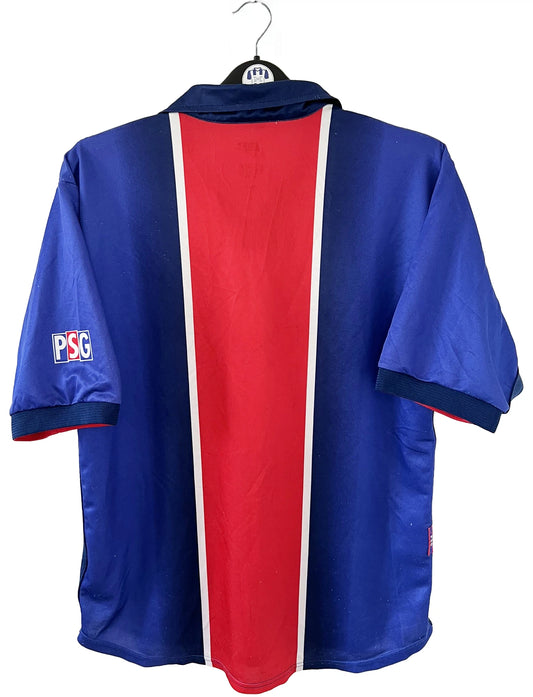 Maillot de foot vintage domicile du PSG de la saison 1998/1999. Le maillot est de couleur bleu blanc et rouge. On peut retrouver l'équipementier nike et le sponsor opel. Il s'agit d'un maillot authentique d'époque.