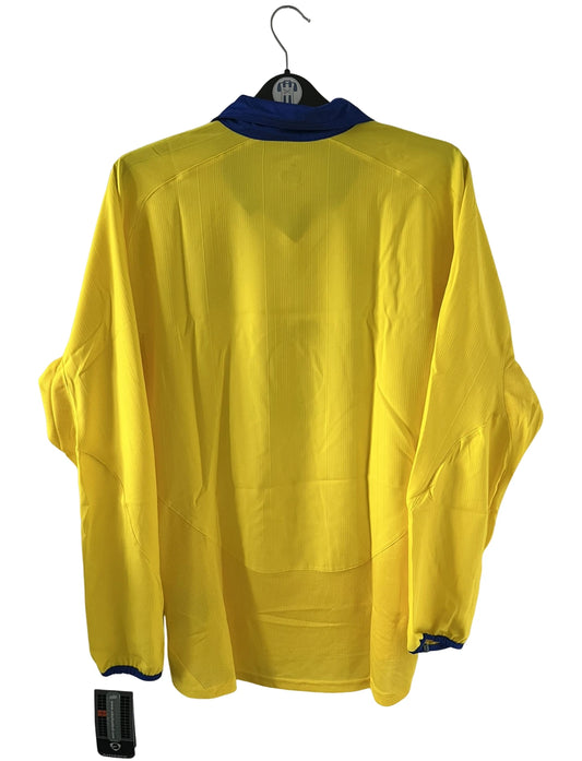 Maillot de foot vintage extérieur jaune d'arsenal de la saison 2003/2004. On peut retrouver l'équipementier Nike et le sponsor O2. Il s'agit d'un maillot authentique d'époque.