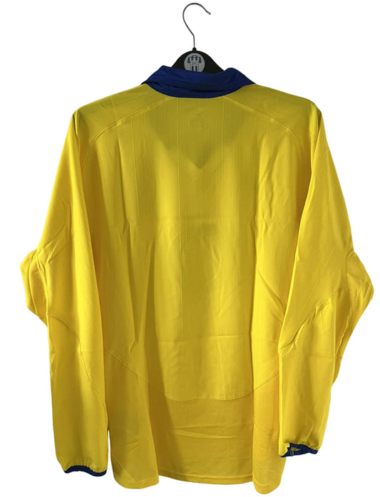 Maillot de foot vintage extérieur jaune d'arsenal de la saison 2003/2004. On peut retrouver l'équipementier Nike et le sponsor O2. Il s'agit d'un maillot authentique d'époque.