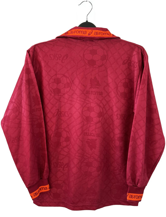 Maillot de foot vintage de l'AS Roma de la saison 1994/1995. Le maillot est de couleur rouge et orange. On peut retrouver l'équipementier asics et le sponsor nuova tirrena. Il s'agit d'un maillot authentique d'époque.