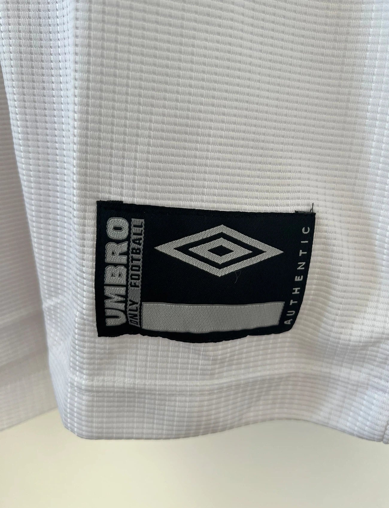 Maillot de foot vintage domicile blanc et noir de Santos de la saison 2000/2001. On peut retrouver l'équipementier Umbro et le sponsor Alphaclub. Il s'agit d'un maillot authentique d'époque.