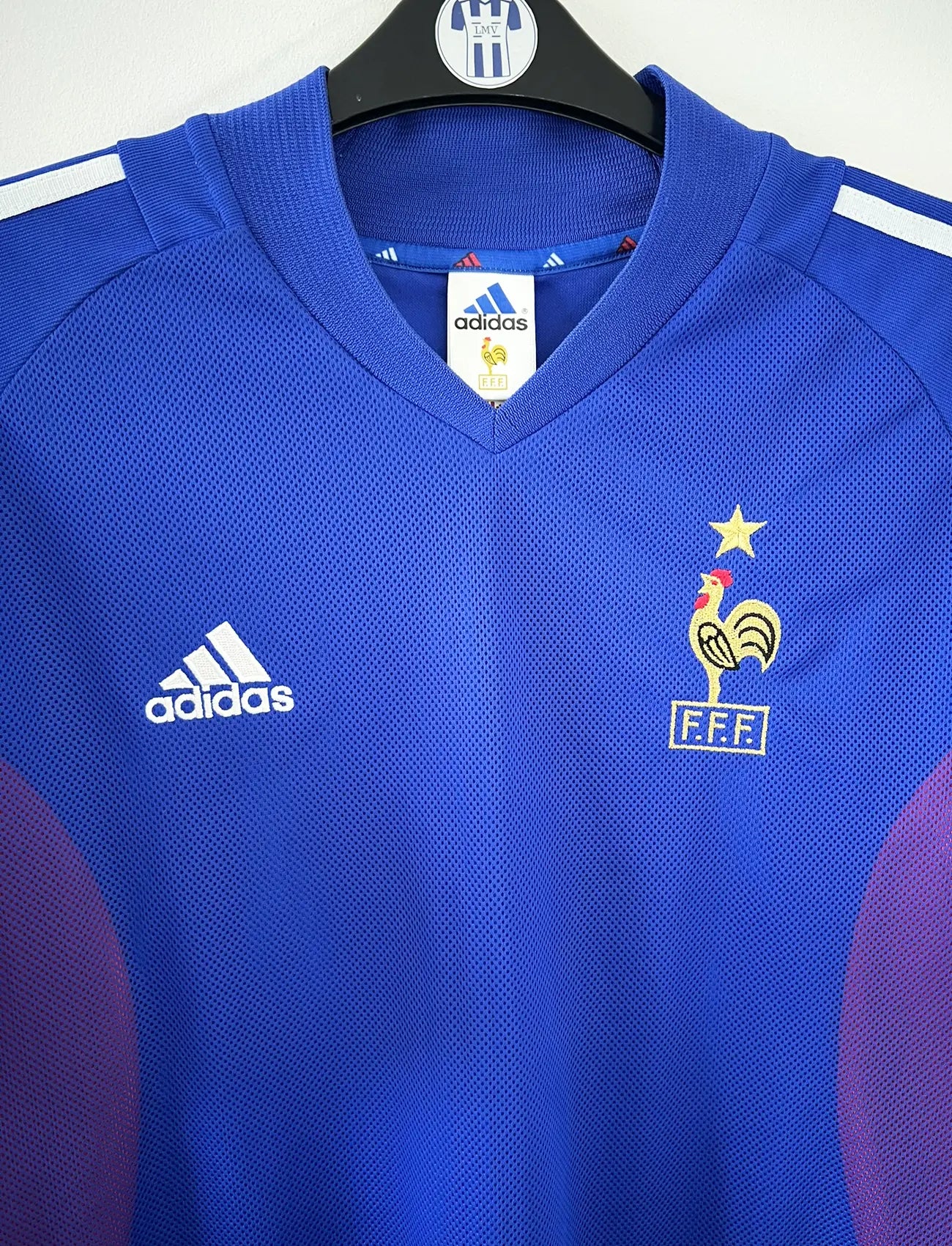 Maillot de foot vintage domicile de l'équipe de france 2002. Le maillot est de couleur bleu blanc et rouge. On peut retrouver l'équipementier adidas. Le maillot est floqué du numéro 10 Zinedine Zidane. Il s'agit d'un maillot authentique d'époque comportant les numéros 139531.