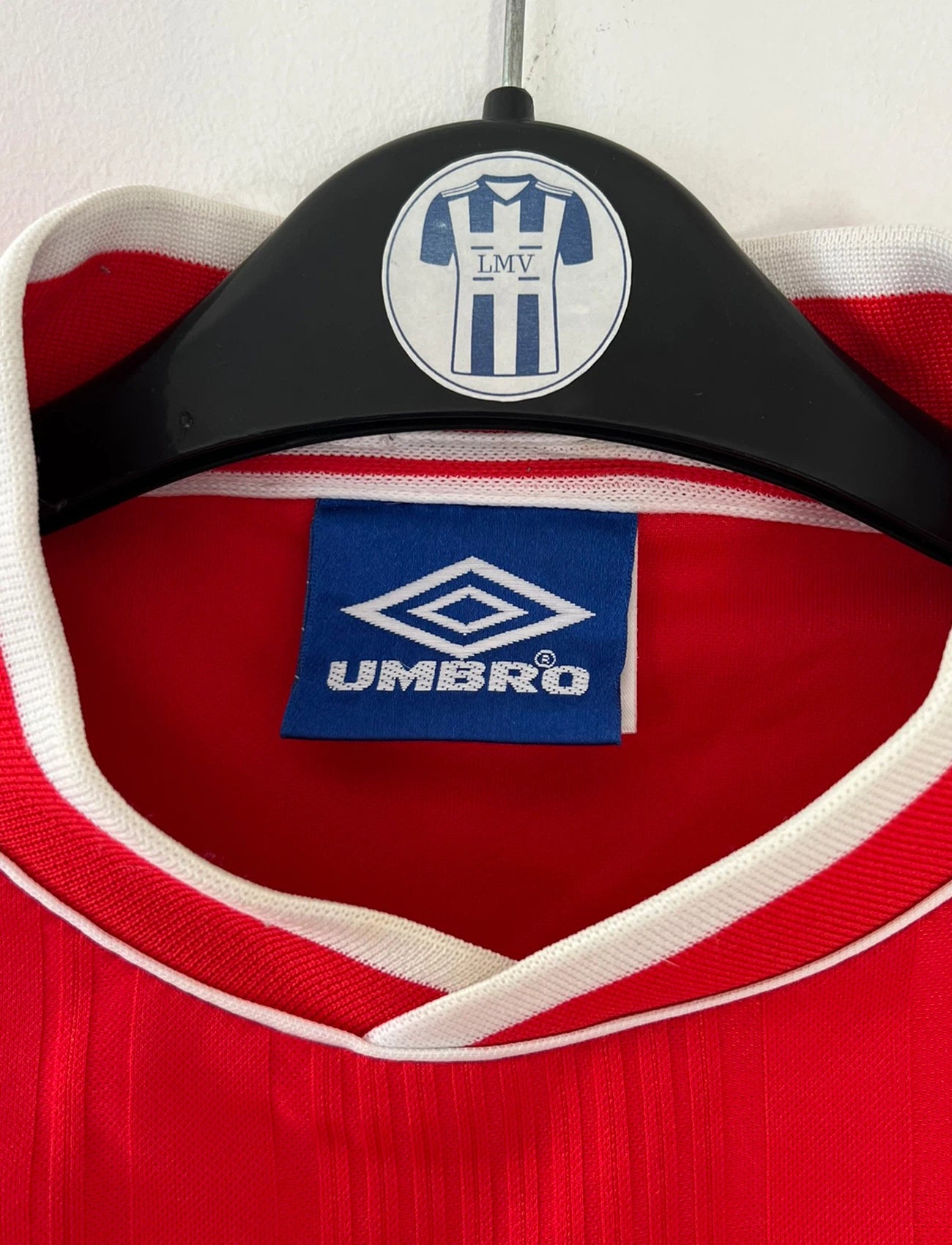 Maillot de foot vintage domicile rouge et blanc de l'Ajax Amsterdam saison 1999/2000. On peut retrouver l'équipementier Umbro et le sponsor ABN-AMRO. Il s'agit d'un maillot authentique d'époque issu du stock pro.