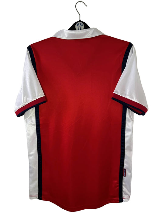 Maillot de foot vintage domicile rouge et blanc d'Arsenal de la saison 1998/1999. On peut retrouver l'équipementier Nike et le sponsor JVC. Il s'agit d'un maillot authentique d'époque.