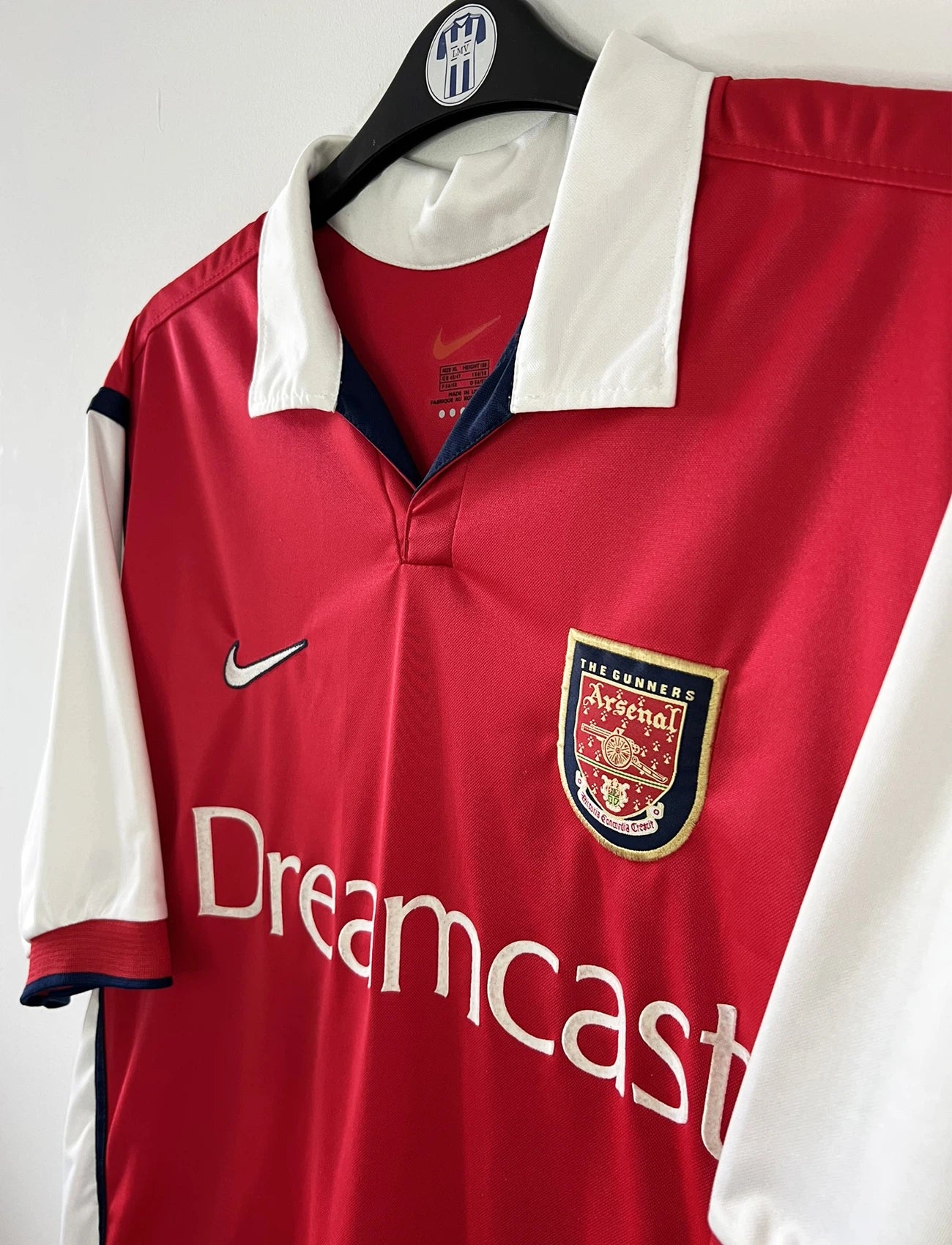 Maillot de foot vintage domicile rouge d'arsenal de la saison 1999/2000. On peut retrouver l'équipementier Nike et le sponsor Dreamcast. Le maillot est floqué du numéro 11 Marc Overmars. Il s'agit d'un maillot authentique d'époque.