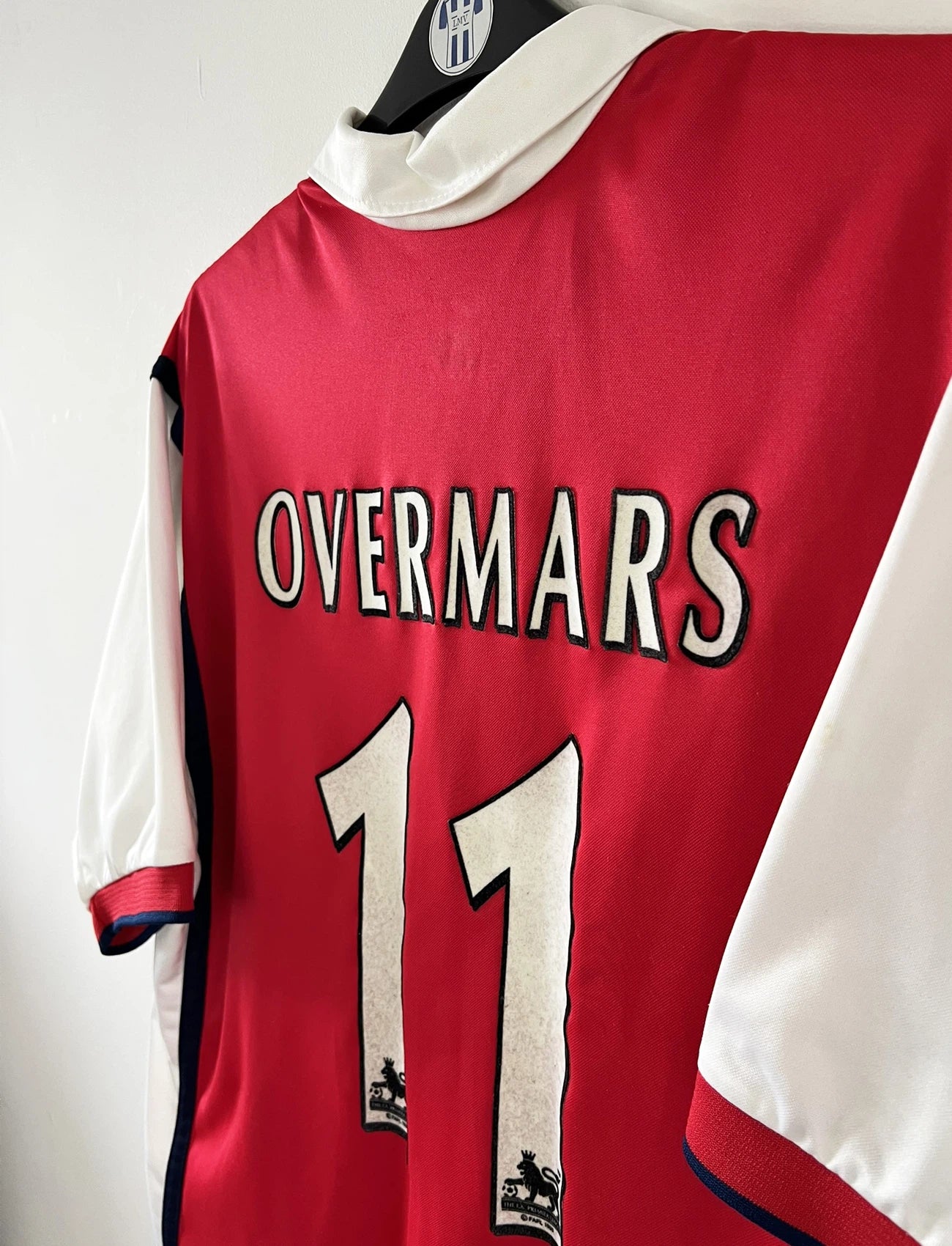 Maillot de foot vintage domicile rouge d'arsenal de la saison 1999/2000. On peut retrouver l'équipementier Nike et le sponsor Dreamcast. Le maillot est floqué du numéro 11 Marc Overmars. Il s'agit d'un maillot authentique d'époque.