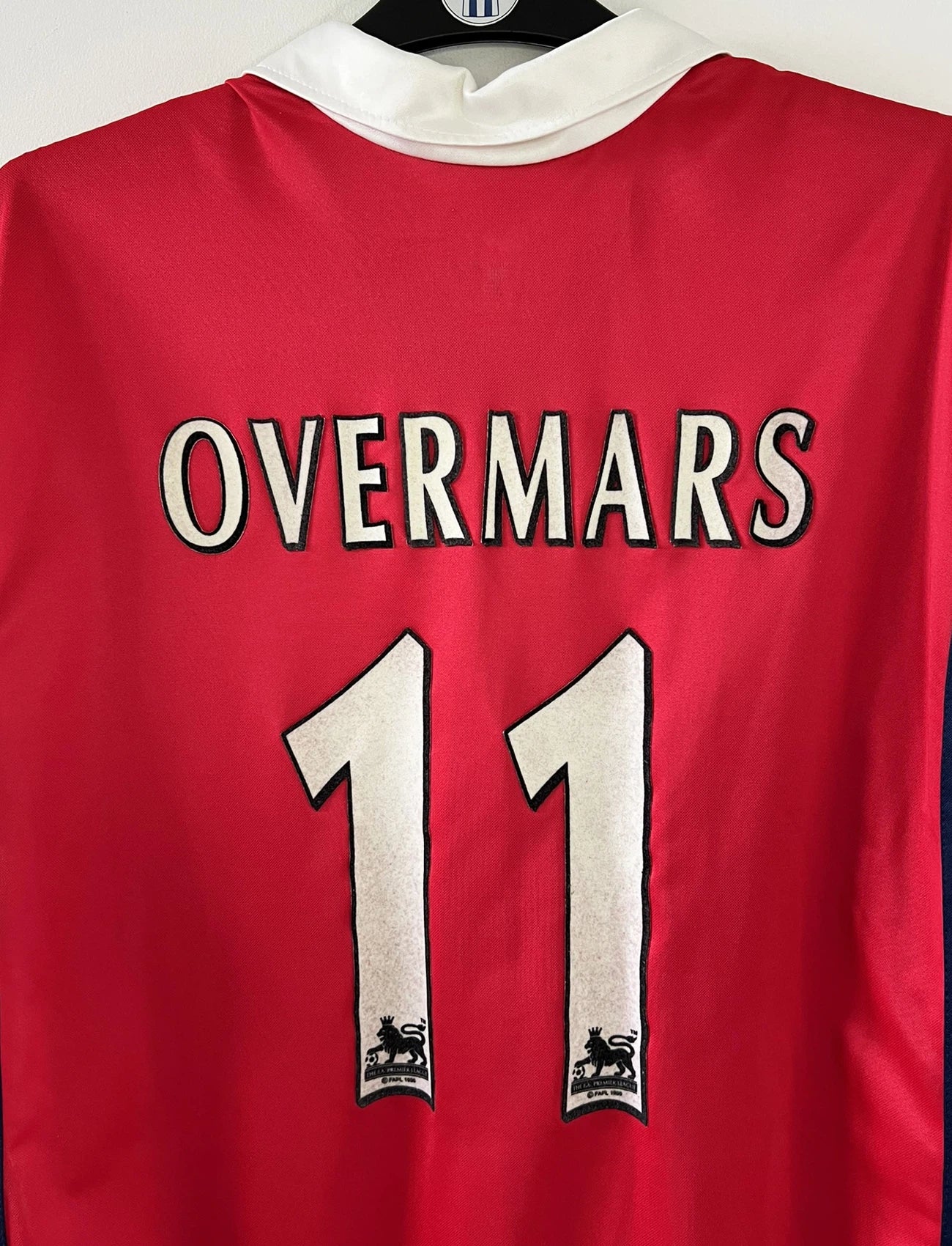 Maillot de foot vintage domicile rouge d'arsenal de la saison 1999/2000. On peut retrouver l'équipementier Nike et le sponsor Dreamcast. Le maillot est floqué du numéro 11 Marc Overmars. Il s'agit d'un maillot authentique d'époque.