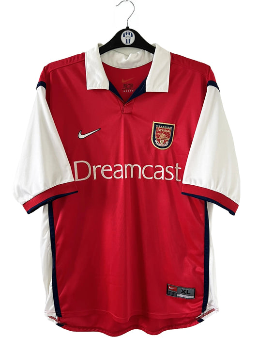 Maillot de foot vintage domicile rouge d'arsenal de la saison 1999/2000. On peut retrouver l'équipementier Nike et le sponsor Dreamcast. Le maillot est floqué du numéro 11 Marc Overmars. Il s'agit d'un maillot authentique d'époque.