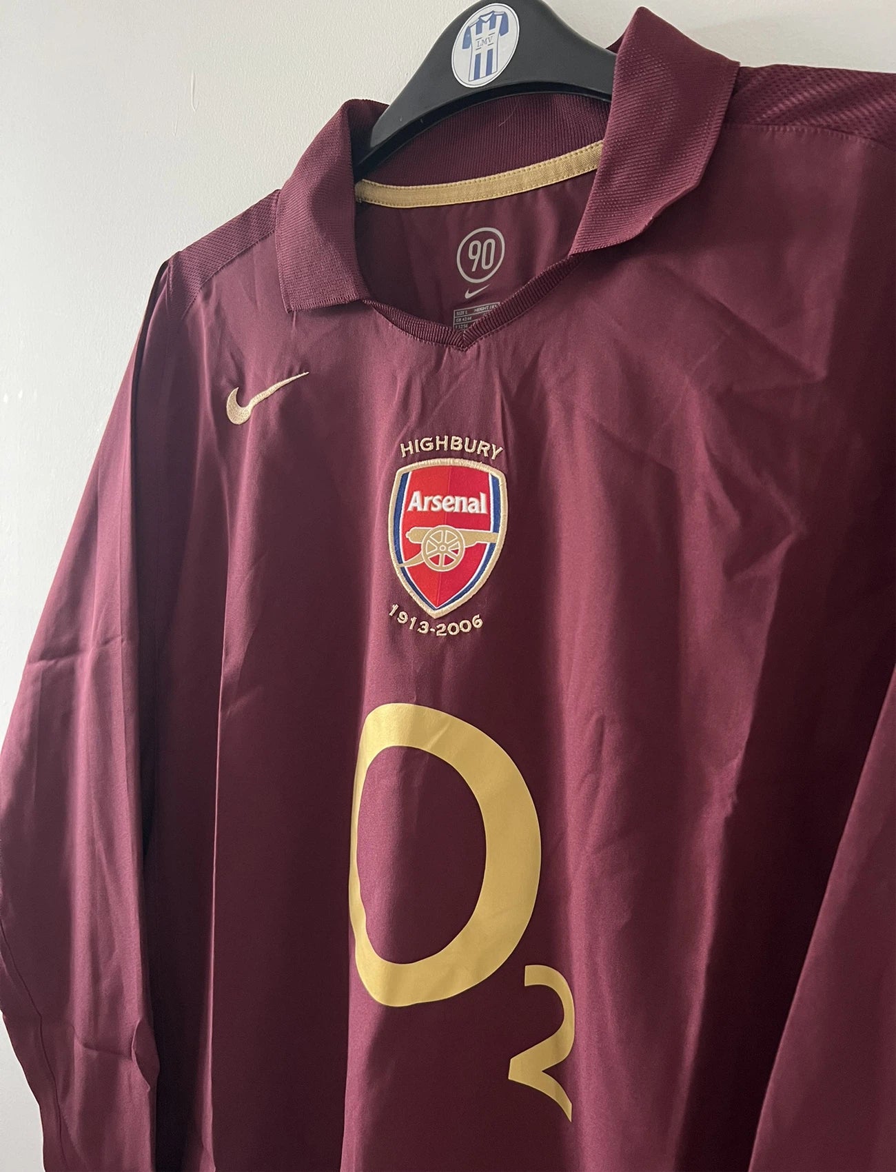Maillot de foot vintage domicile rouge d'Arsenal de la saison 2005/2006. On peut retrouver l'équipementier Nike et le sponsor O2. Il s'agit d'un maillot authentique d'époque.