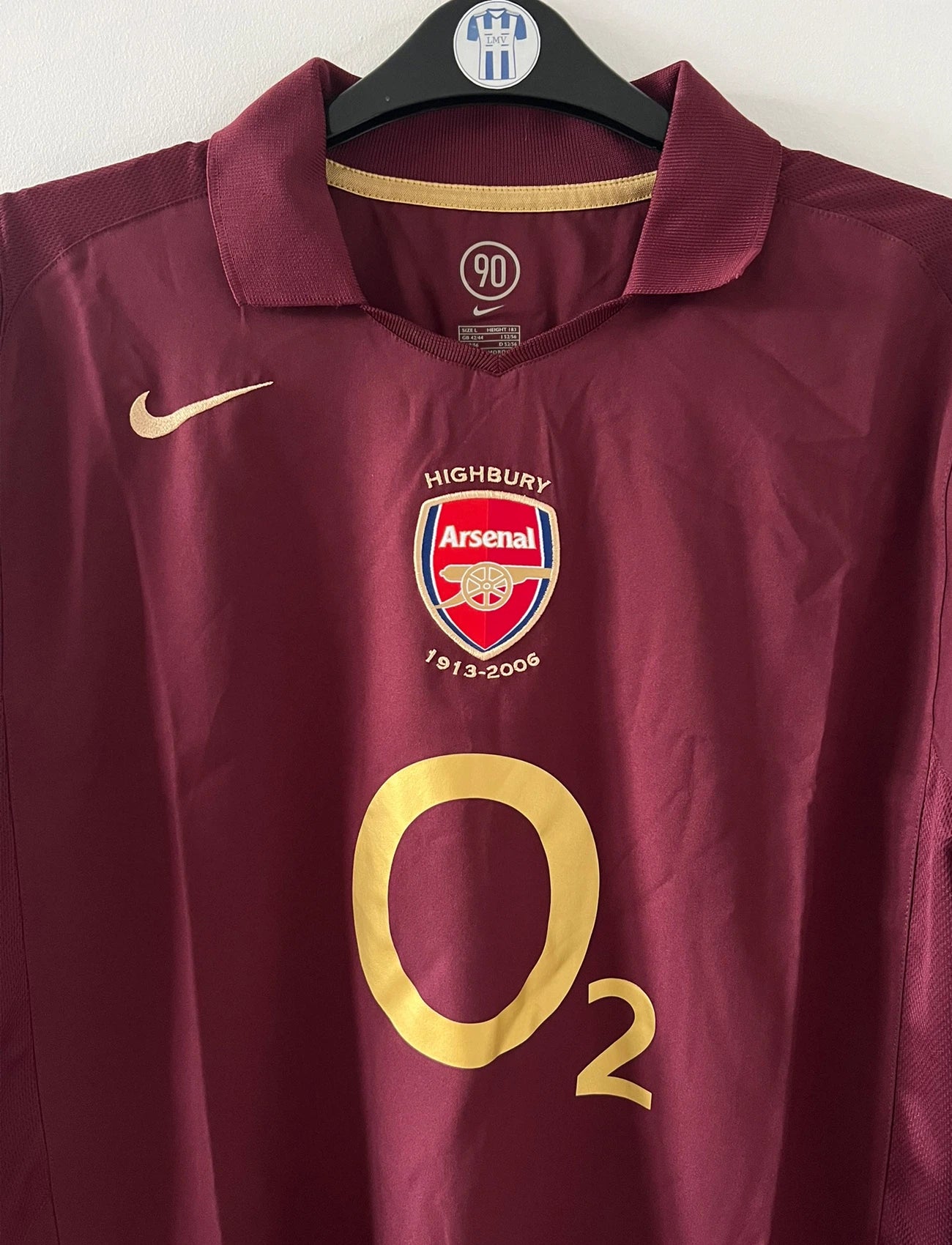Maillot de foot vintage domicile rouge d'Arsenal de la saison 2005/2006. On peut retrouver l'équipementier Nike et le sponsor O2. Il s'agit d'un maillot authentique d'époque.