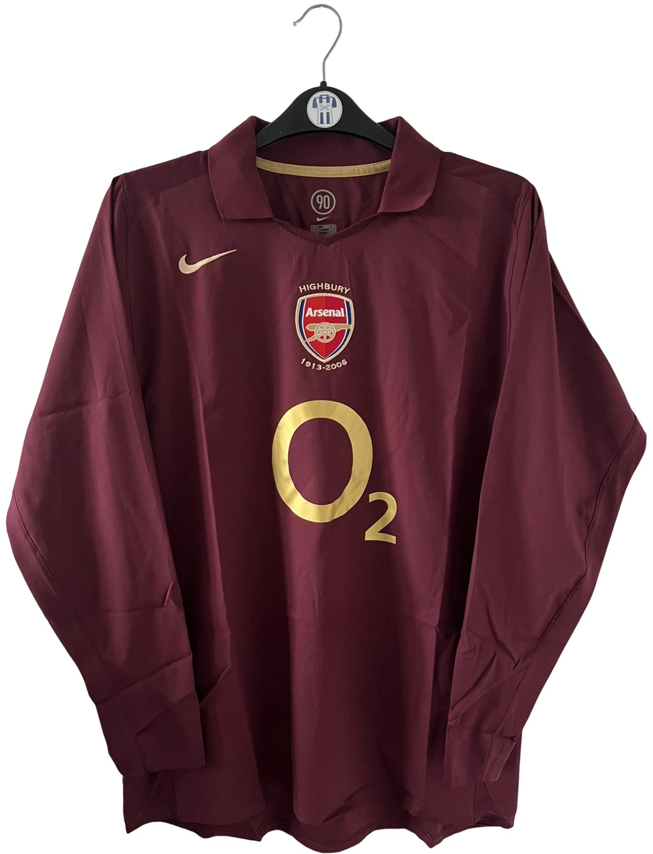 Maillot de foot vintage domicile rouge d'Arsenal de la saison 2005/2006. On peut retrouver l'équipementier Nike et le sponsor O2. Il s'agit d'un maillot authentique d'époque.