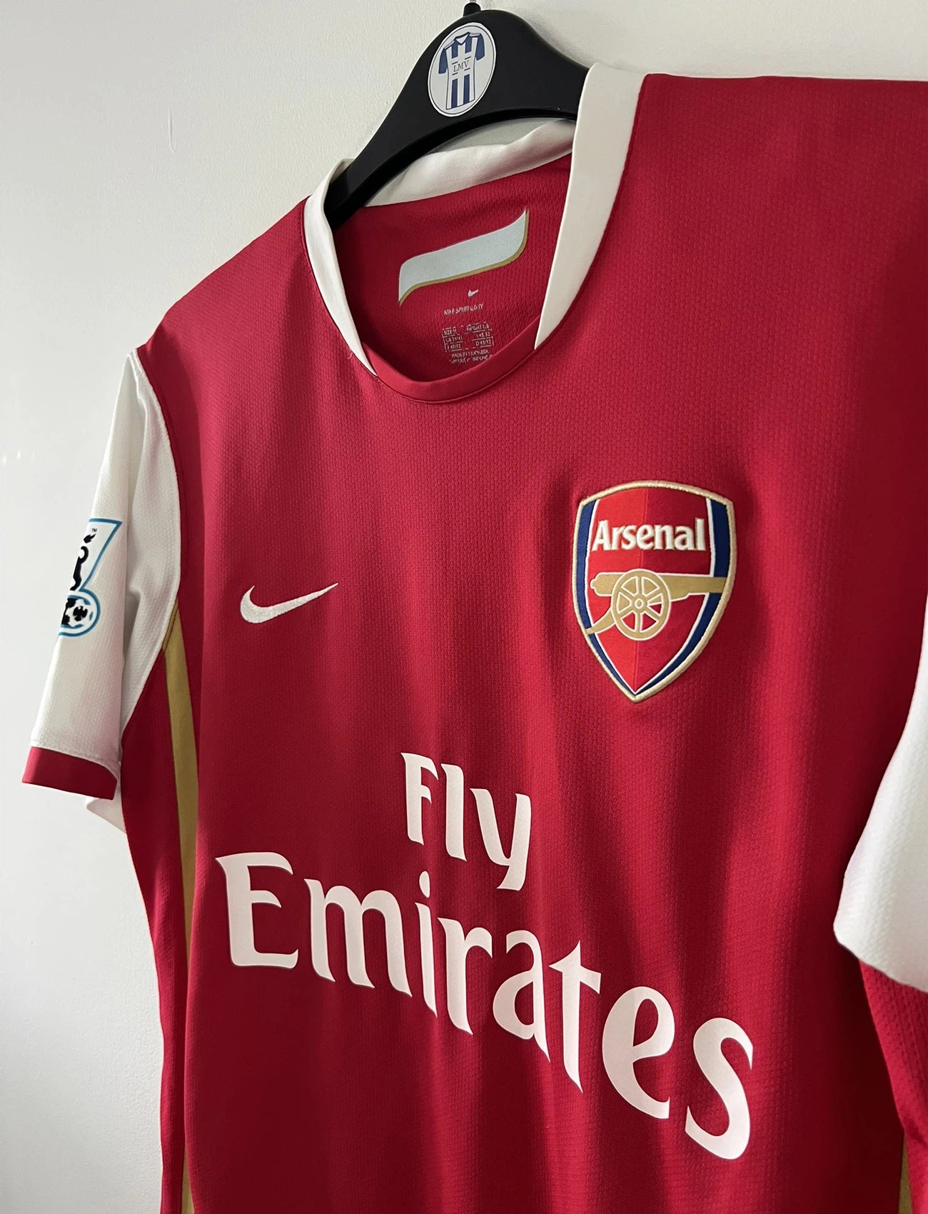 Maillot de foot vintage domicile rouge et blanc d'arsenal de la saison 2006-2007. On peut retrouver l'équipementier nike et le sponsor fly emirates. Le maillot est floqué du numéro 14 Thierry Henry. Il s'agit d'un maillot authentique d'époque comportant l'étiquette numéro 146769