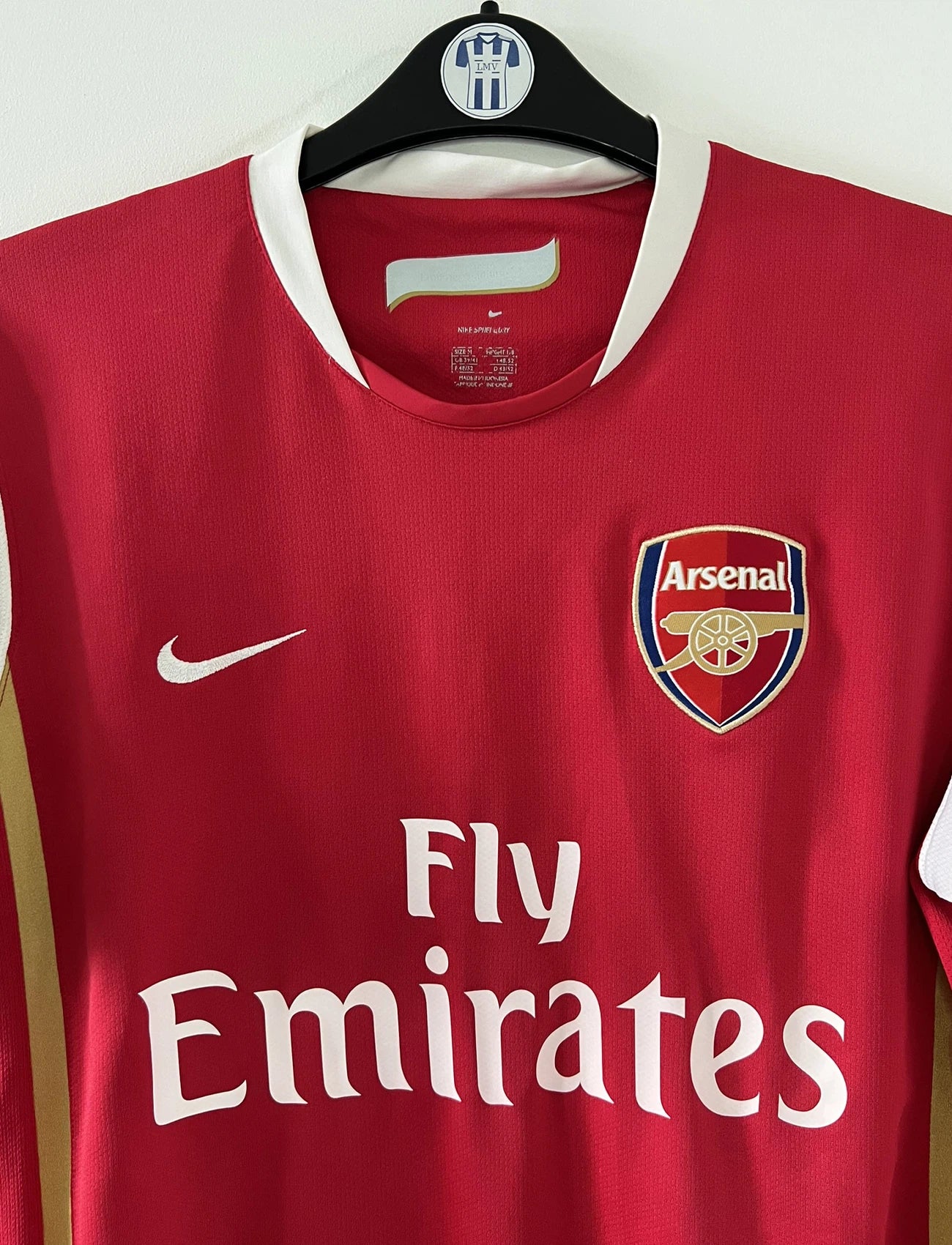 Maillot de foot vintage domicile rouge et blanc d'arsenal de la saison 2006-2007. On peut retrouver l'équipementier nike et le sponsor fly emirates. Le maillot est floqué du numéro 14 Thierry Henry. Il s'agit d'un maillot authentique d'époque comportant l'étiquette numéro 146769