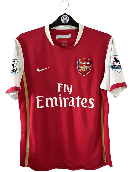 Maillot de foot vintage domicile rouge et blanc d'arsenal de la saison 2006-2007. On peut retrouver l'équipementier nike et le sponsor fly emirates. Le maillot est floqué du numéro 14 Thierry Henry. Il s'agit d'un maillot authentique d'époque comportant l'étiquette numéro 146769