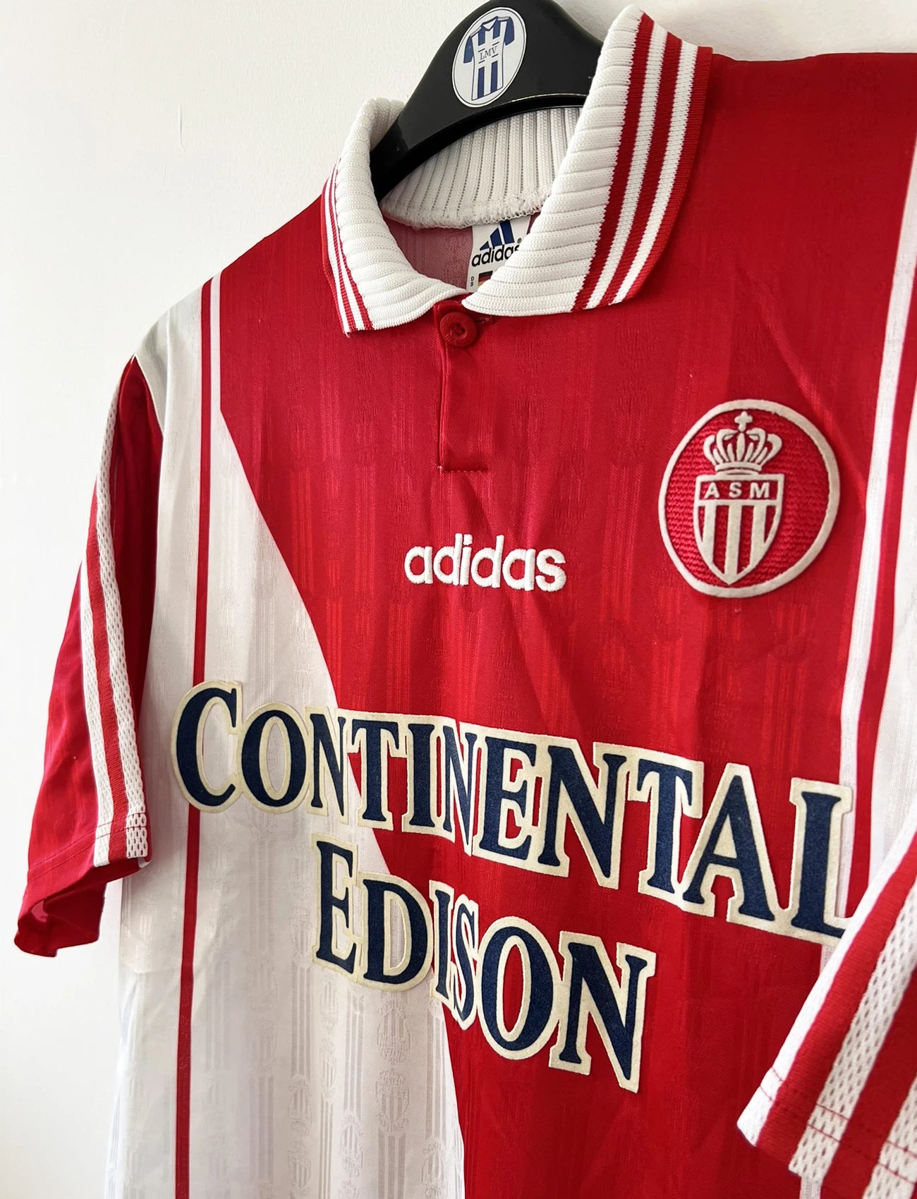 Maillot de foot vintage domicile rouge et blanc de l'AS Monaco de la saison 1997/1998. On peut retrouver l'équipementier Adidas et le sponsor Continental Edison. Il s'agit d'un maillot authentique d'époque.