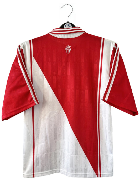 Maillot de foot vintage domicile rouge et blanc de l'AS Monaco de la saison 1997/1998. On peut retrouver l'équipementier Adidas et le sponsor Continental Edison. Il s'agit d'un maillot authentique d'époque.