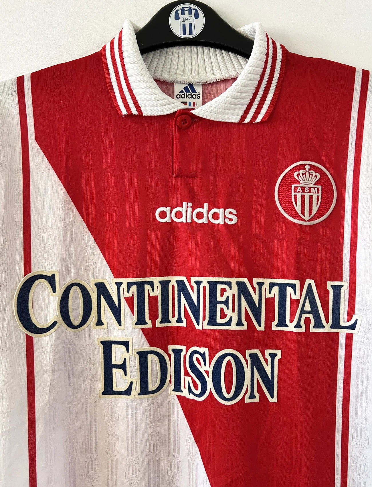 Maillot de foot vintage domicile rouge et blanc de l'AS Monaco de la saison 1997/1998. On peut retrouver l'équipementier Adidas et le sponsor Continental Edison. Il s'agit d'un maillot authentique d'époque.