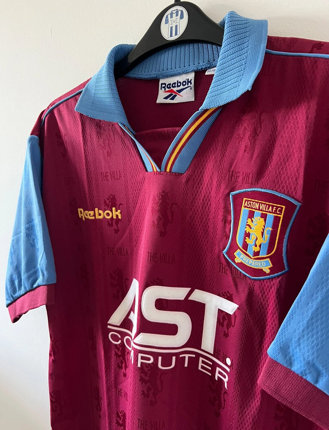 Maillot de foot vintage domicile rouge et bleu d'aston villa de la saison 1995/1997. On peut retrouver l'équipementier Reebok et le sponsor AST Computer. Il s'agit d'un maillot authentique d'époque.