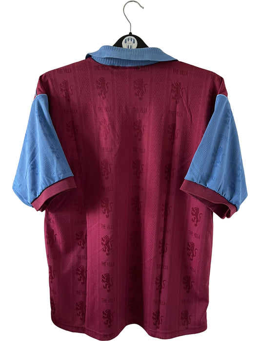 Maillot de foot vintage domicile rouge et bleu d'aston villa de la saison 1995/1997. On peut retrouver l'équipementier Reebok et le sponsor AST Computer. Il s'agit d'un maillot authentique d'époque.