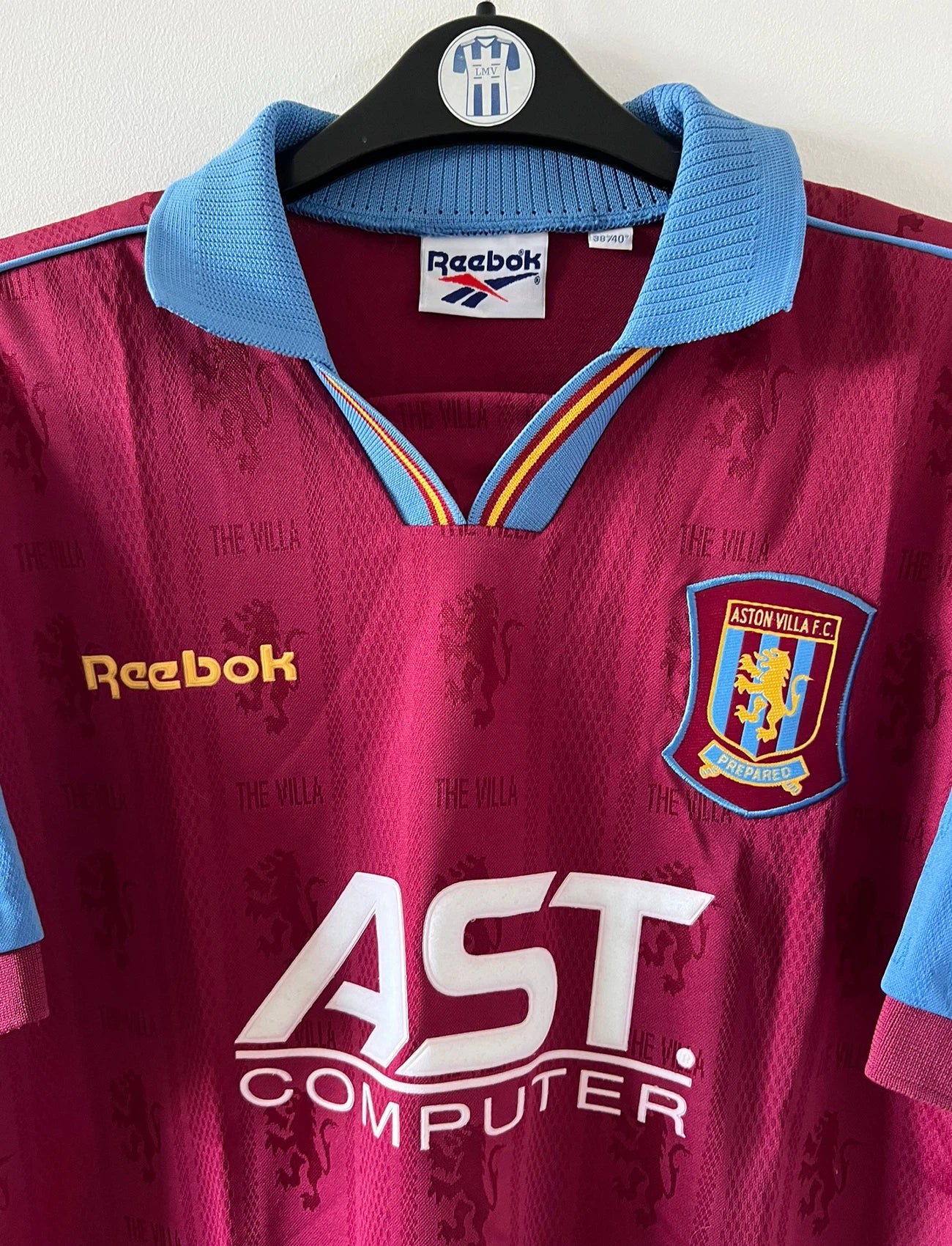 Maillot de foot vintage domicile rouge et bleu d'aston villa de la saison 1995/1997. On peut retrouver l'équipementier Reebok et le sponsor AST Computer. Il s'agit d'un maillot authentique d'époque.