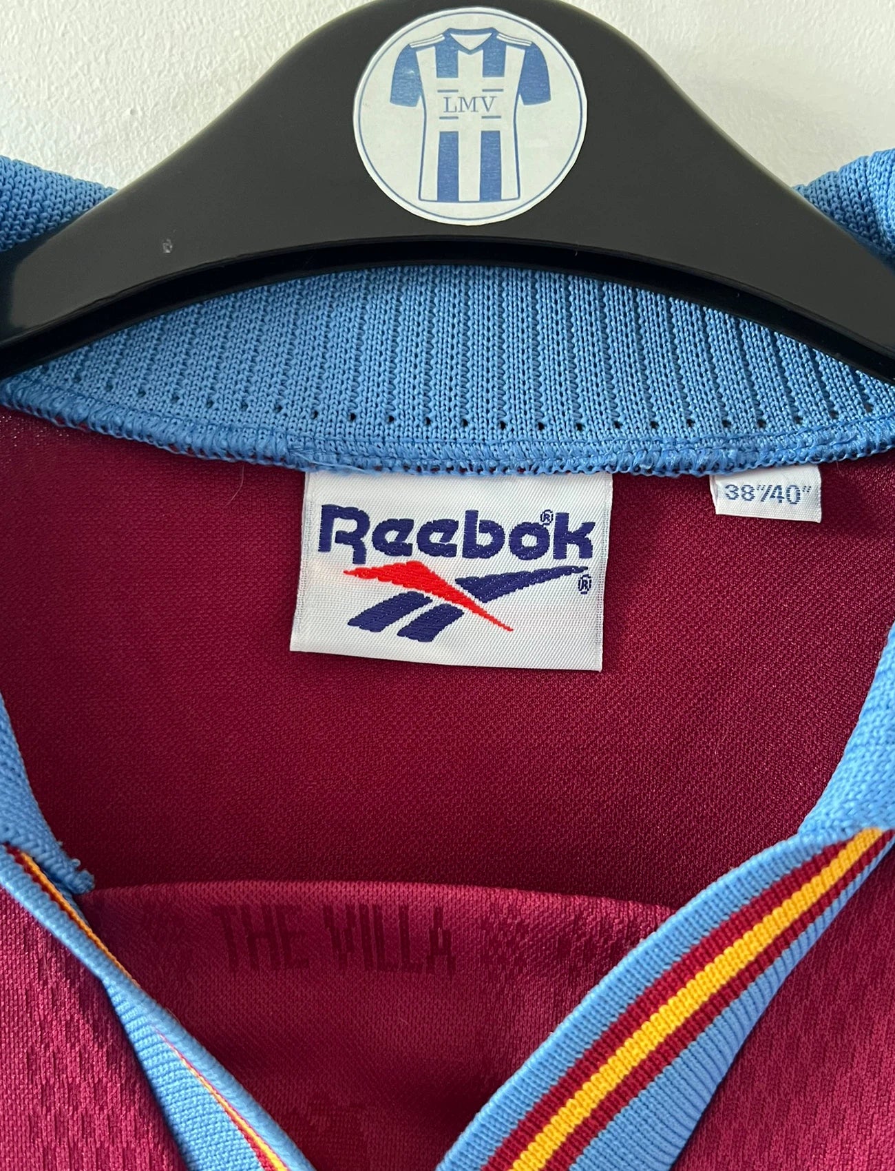 Maillot de foot vintage domicile rouge et bleu d'aston villa de la saison 1995/1997. On peut retrouver l'équipementier Reebok et le sponsor AST Computer. Il s'agit d'un maillot authentique d'époque.